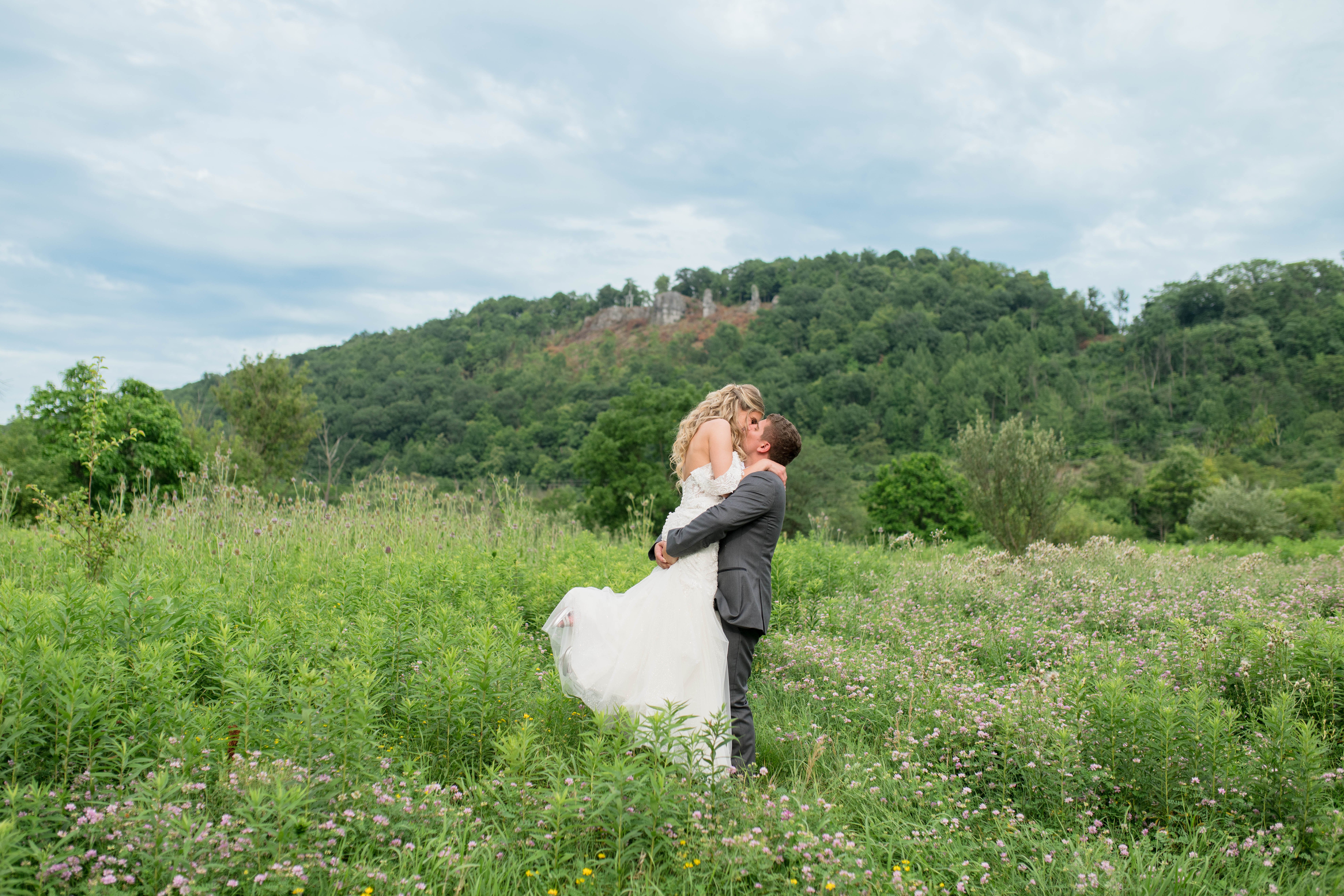 Bride and Groom in field twirling wedding photo